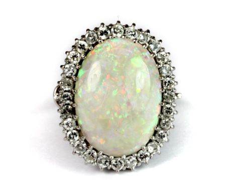 A superb white metal (tested 18ct white gold) ring set with a large polished natural opal (23mm approx) surrounded by diamond