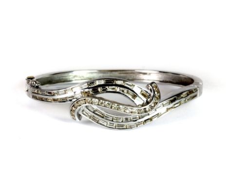A superb 18ct white gold hinged bangle lavishly set with baguette and brilliant cut diamonds. Est. £2000 - 3000