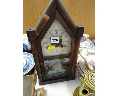 A vintage American architectural mantel clock with painted beehive style door