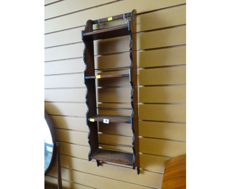 A mahogany narrow hanging shelf unit