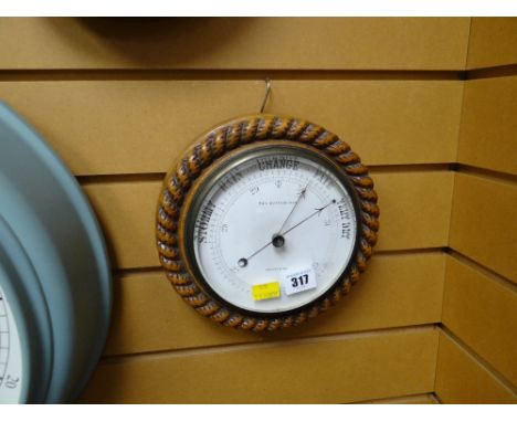 A vintage circular carved oak rope patterned surround barometer made by B & A Butterfield of Bradford