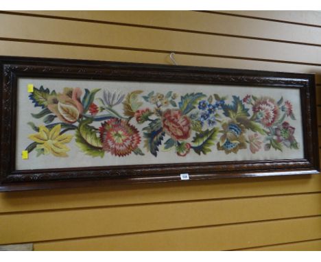 A carved mahogany framed tapestry / embroidery of flowers dated 1946