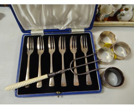 Set of six hallmarked silver cake forks, four various hallmarked napkin rings together with a silver necked toasting fork