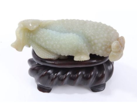 Chinese green jade carving of a fruit, 9.5cm, on associated hardwood stand (2)