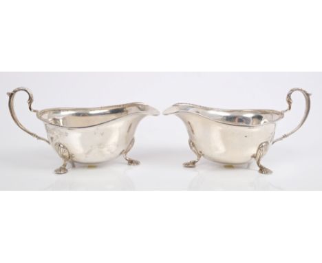 Pair 1930s silver sauce boats of conventional form, with bead borders and scroll handles, on three shell feet (Birmingham 193