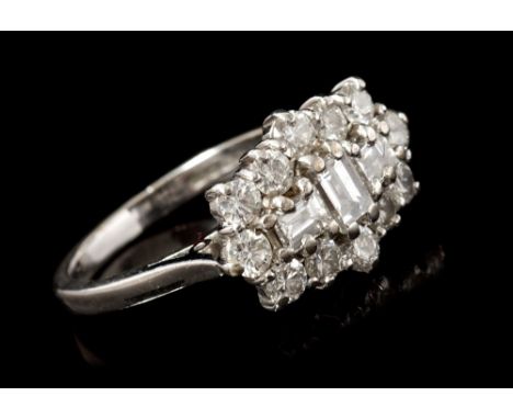 Diamond cluster ring, the three central step cut diamonds surrounded by a border of twelve round brilliant cut diamonds in wh