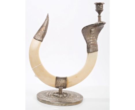 Indian white metal mounted boar's tusk candlestick in the form of a cobra, on an oval base with figurative and floral decorat