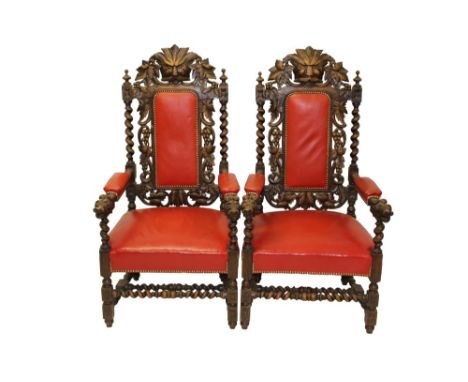Large pair of Victorian carved oak upholstered elbow chairs, each upholstered pad back with mask cresting and vine and barley