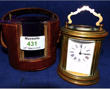 An early 20th century French miniature brass cased oval carriage clock in original oval diced morocco covered carrying case, 