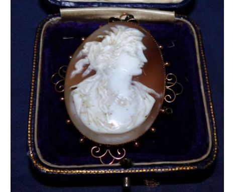 An oval female head cameo brooch, the filigree and ball surround stamped '9CT'