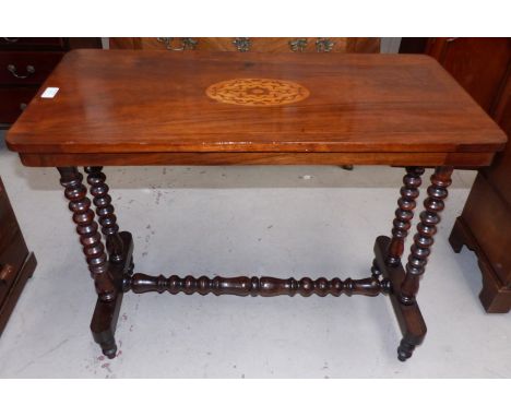 A Victorian walnut stretcher table with inlaid decoration and turned bobbin legs