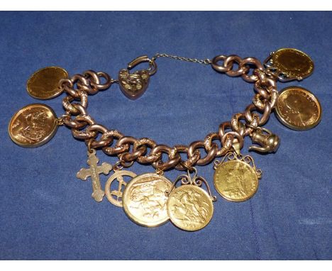 A curb chain charm bracelet stamped '9CT', set with 5 sovereigns, 4 in clip mounts, 2 half sovereigns, with heart lock and 3 