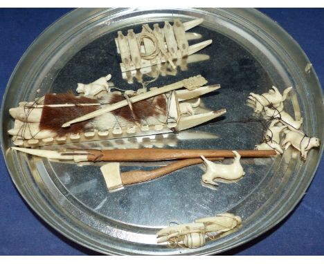 A selection of Inuit carved items including 2 sledges; dogs; harpoon; axe; etc.