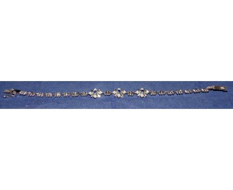 A white metal gate bracelet with beaded border and 3 blue and white sapphire clusters, stamped '750'
