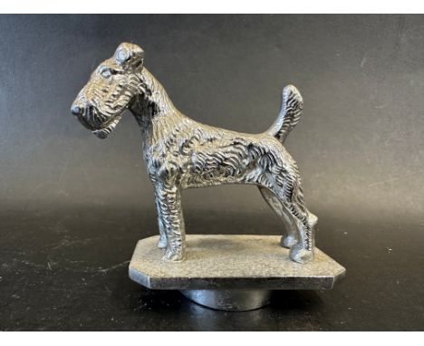 An Airedale terrier car mascot stamped Desmo to front and Copyright to back, approx. 3" long. 