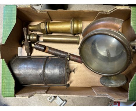 An early brass swivel fire engine spot lamp, a steel generator, a brass hose nozzle and two whistles.