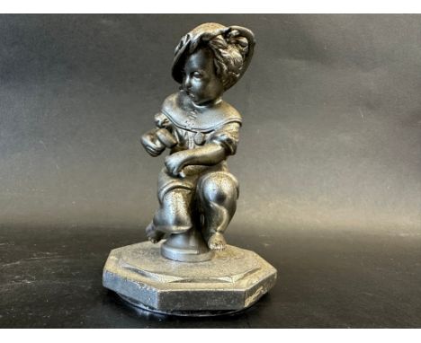 A car mascot in the form of a seated child holding a hammer and chisel, radiator cap mounted, approx. 4 1/2" tall overall. 