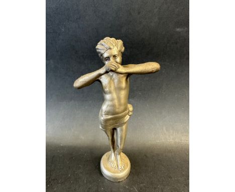 A car mascot in the form of a boy swathed in cloth, playing a wind instrument. Signed and dated to rear of base: Elsie Chard 