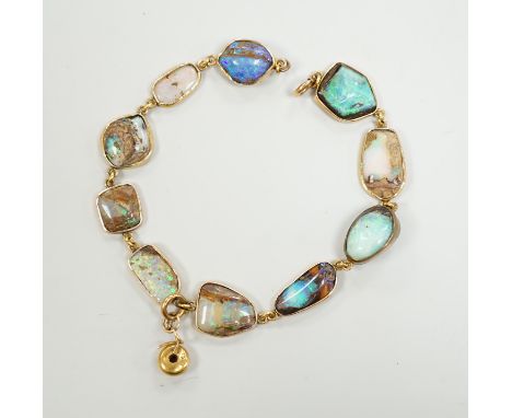 An early 20th century yellow metal and opal set bracelet, of various shapes and hung with central 15ct and diamond chip set c