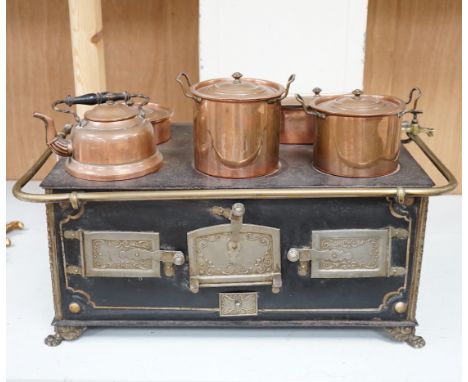A Continental iron child's toy range/ stove, with a collection of copper fitted pans and a similar kettle, range 46cm wide x 