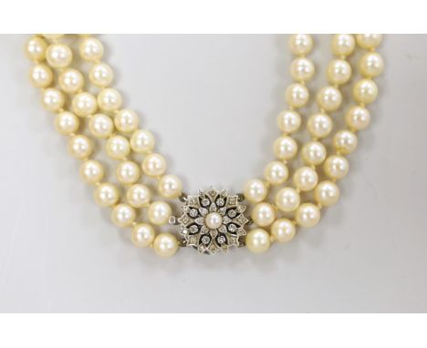 A 1960's triple strand cultured pearl choker necklace, with diamond and cultured pearl cluster set white metal clasp, 40cm, w