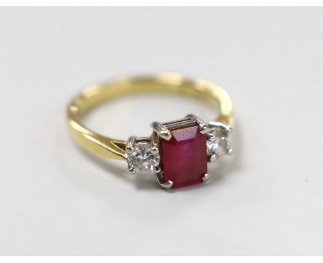 A modern 18ct gold, ruby and diamond set three stone ring, size M/N,gross weight 3.8 grams.