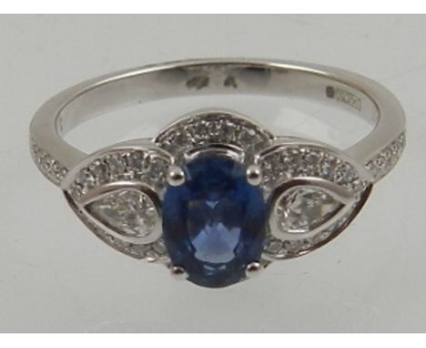 An 18 carat white gold, diamond, and light blue sapphire cluster ring