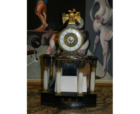 A late 19th century mantle clock, the enamelled dial with Roman numerals and engine turned interior, above four Corinthian co