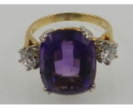 A large 18ct yellow gold amethyst ring, the central stone flanked by two diamonds