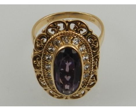 An 18 carat yellow gold , amethyst, and white sapphire ring, the stones set in an oval openwork mount.