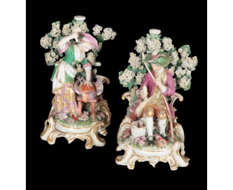 A PAIR OF 18TH CENTURY DUESBURY &amp; CO DERBY PORCELAIN CANDLESTICKS - A DOMESTIC COUPLE modelled butchering a cockerel and 