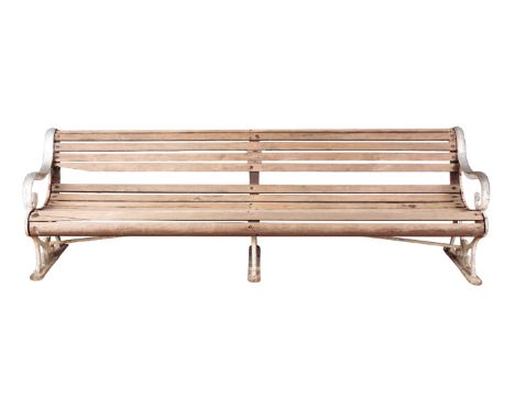 A WHITE-PAINTED CAST-IRON GARDEN BENCH 20th century, with scrolling and pierced ends, joined by stained and weathered wooden 