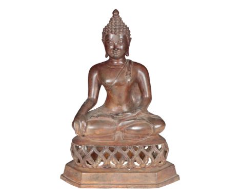 A BRONZE FIGURE OF BUDDHA seated cross-legged, on a raise pierced base, 38.5cm high