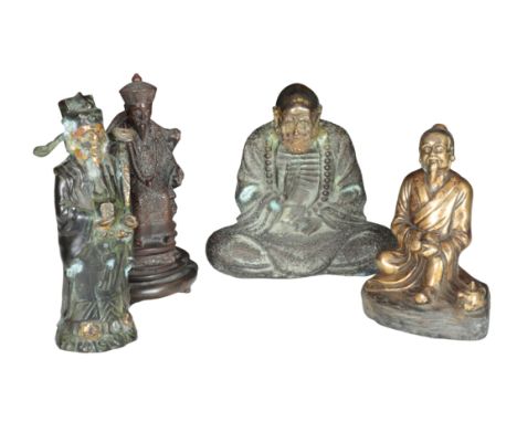 A CAST BRONZE FIGURE OF A SEATED HOLY MAN&nbsp;positing cross-legged with a raised hand, and traces of the original gilt deco
