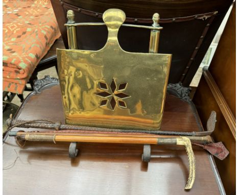 A brass book rest together with a hunting whip and other whips