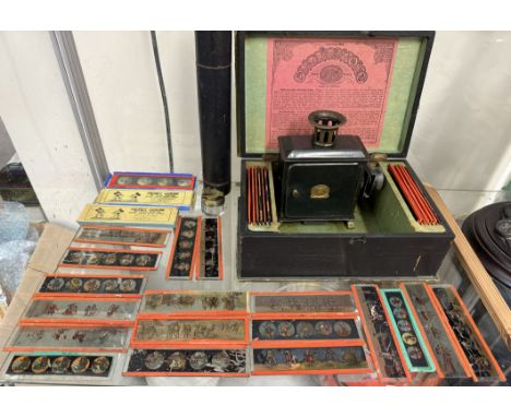 A Tin plate magic lantern and slides together with a quill tube and inkwell