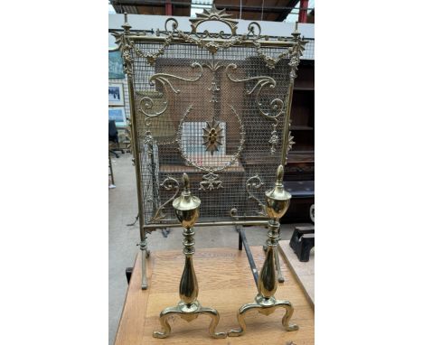 A brass fire screen with a fan shaped handle and grill together with a pair of brass andirons