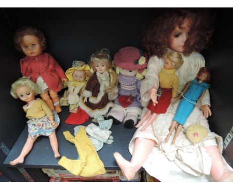 A shelf of 1960's and later celluloid and rubberised dolls with clothing including Mattel Sindy style etc