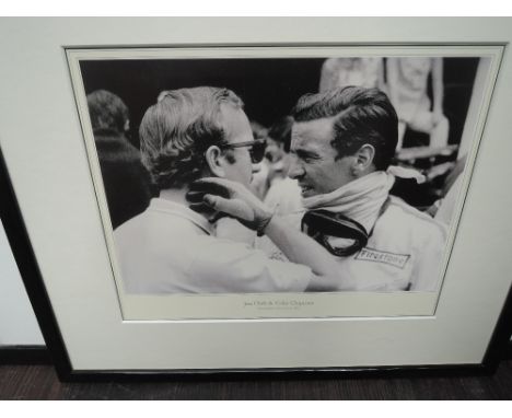 Five black and white framed prints, vintage motor racing interest including Jim Clark and Stirling Moss with one bearing sign
