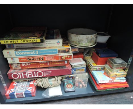 A shelf of mixed vintage games and toys including Connect 4, Chinese Checkers, card games etc