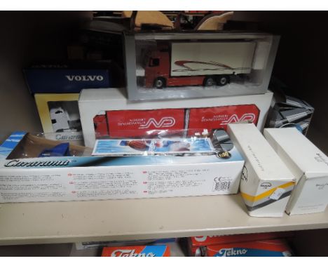 A shelf of Cararama, Volvo and similar diecast articulated wagons, with boxes