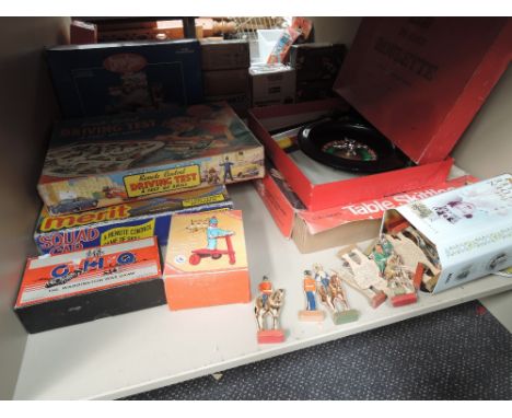 A shelf of vintage games including Casdon Table Skittles, The Waddington War Game, Driving Test, Chad Valley wooden military 