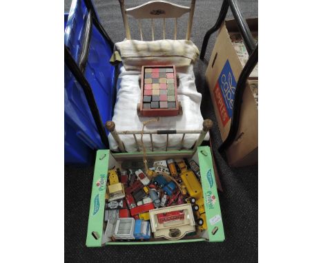 A vintage wooden dolls bed, a wooden pull along truck with building blocks and a selection of mixed diecasts including Tonka,