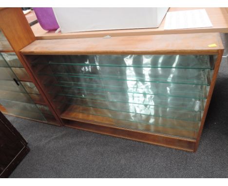 An oak framed model display case having 6 glass shelves and one fixed wooden shelf with sliding glass doors