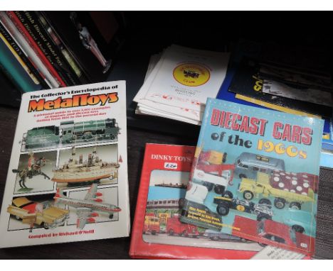 A shelf of toy collectors reference books and magazines including Metaltoys Encyclopedia, Dinky Toys & Model Miniatures by Mi