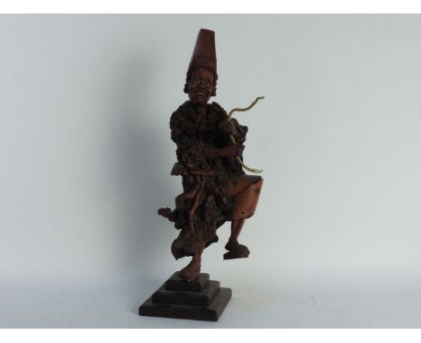 A root carved oriental lamp, a Balinese carved figure