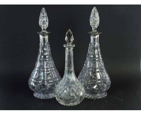 A pair of cut glass decanters with silver collars and one other decanter (3)