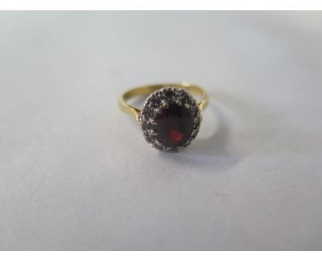 A synthetic corundum and diamond set cluster ring - yellow shank and raised, chenier shoulders to centre, oval, synthetic cor