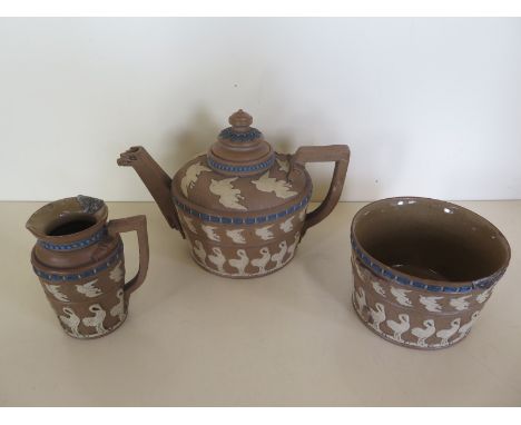 A 19th century Doulton, Lambeth silicon ware teapot and lid, together with sugar bowl and milk jug decorated in the Egyptian-