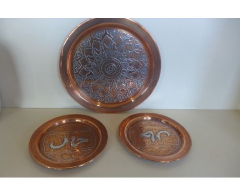 Three Islamic copper plates with white metal inlay, 29cm x 19cm diameter 
